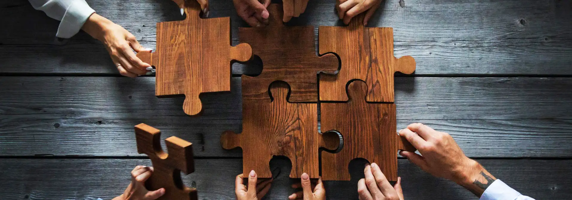Une équipe technique travaille à la réalisation d'un puzzle en bois.