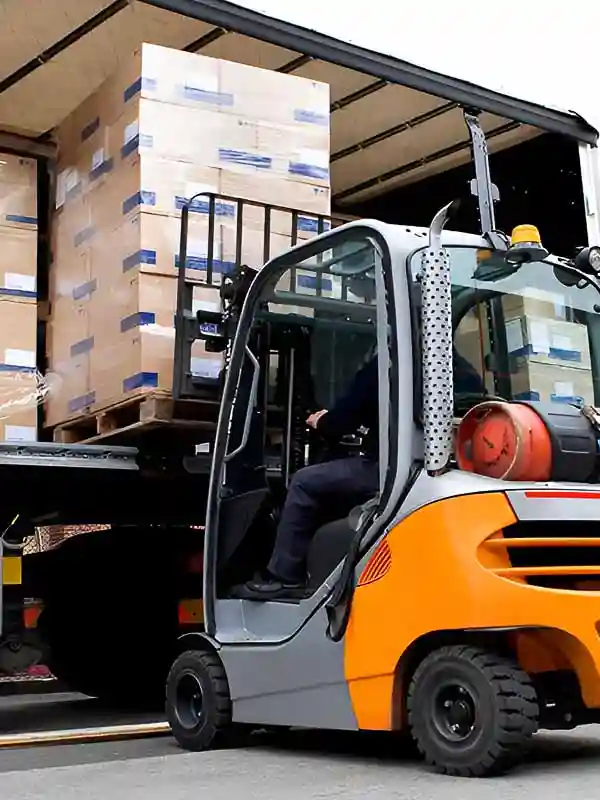 RC après livraison : Un camion livre des denrées déchargées par un engin de manutention.