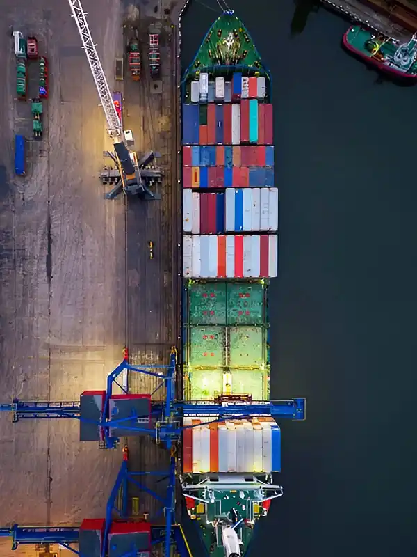 Transport maritime par bateau procédant au chargement de conteneurs depuis un port international.